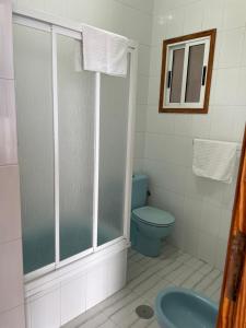 y baño con aseo azul y ducha. en ROCAMAR en La Restinga