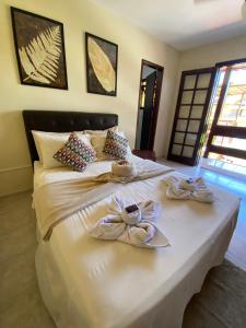 Una gran cama blanca con servilletas y arcos. en Pousada Maricá en Maricá