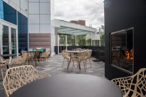 un patio con mesa, sillas y chimenea en Residence Inn by Marriott The Bronx at Metro Center Atrium en Bronx