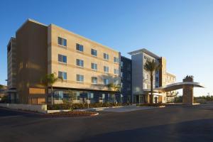 a building with palm trees in front of a street at Fairfield Inn & Suites by Marriott Riverside Moreno Valley in Moreno Valley