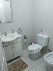 een witte badkamer met een toilet en een wastafel bij Depto Directorio in Buenos Aires