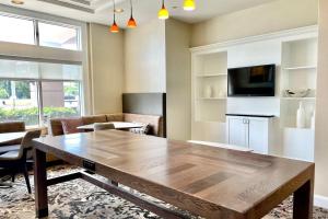 a dining room with a wooden table and a tv at Residence Inn by Marriott Norfolk Airport in Norfolk