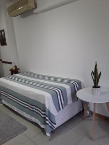uma cama com um cobertor listrado e uma mesa em Depto Directorio em Buenos Aires