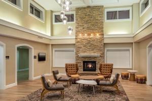 a lobby with a fireplace and chairs and a table at Residence Inn by Marriott Norfolk Airport in Norfolk