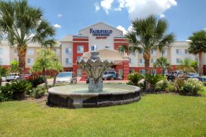 a fountain in the grass in front of a hotel at Fairfield Inn & Suites Laredo in Laredo