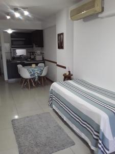 1 dormitorio con cama, mesa y cocina en Depto Directorio en Buenos Aires