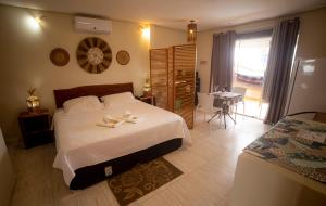 - une chambre avec un grand lit et 2 serviettes dans l'établissement Chalés Alto Da Estância, à Alto Paraíso de Goiás