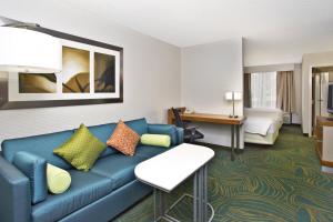 a living room with a blue couch in a hotel room at SpringHill Suites Chicago Elmhurst/Oakbrook Area in Elmhurst