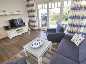 een woonkamer met 2 banken en een tv bij Dünenpark Binz - WG202 mit Terrasse strandnah in Binz