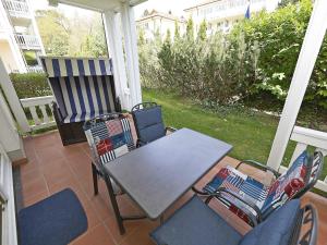 een patio met een tafel en stoelen op een veranda bij Dünenpark Binz - WG202 mit Terrasse strandnah in Binz