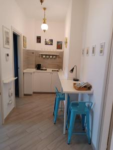 a kitchen with a table and some blue stools at Bnbook Residenza Lo Scoiattolo in Rho