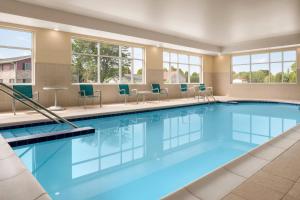 a large swimming pool with chairs and windows at TownePlace Suites by Marriott Janesville in Janesville