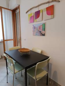 a dining room with a black table and chairs at Bnbook Residenza Lo Scoiattolo in Rho