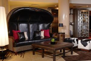 a living room with a black leather couch and a table at Renaissance Denver Downtown City Center Hotel in Denver
