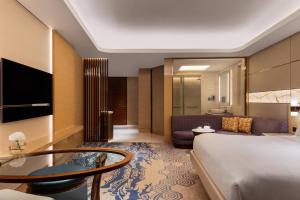 a hotel room with a bed and a living room at JW Marriott Hotel Macau in Macau