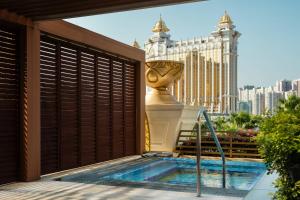 a hot tub on the balcony of a hotel with a view of the city at JW Marriott Hotel Macau in Macau