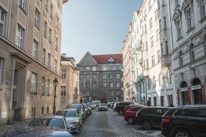 una strada cittadina con auto e edifici parcheggiati di Josefov Riverside Apartment a Praga