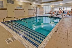 a large swimming pool in a hospital at Courtyard by Marriott Westbury Long Island in Westbury