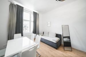 Sala de estar blanca con sofá y espejo en Josefov Riverside Apartment, en Praga