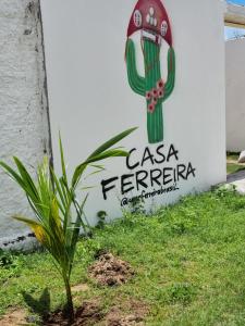 une plante devant un panneau avec un cactus dans l'établissement Casa Ferreira Cumbuco, à Caucaia