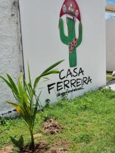 a plant in front of a sign with a cactus at Casa Ferreira Cumbuco in Caucaia