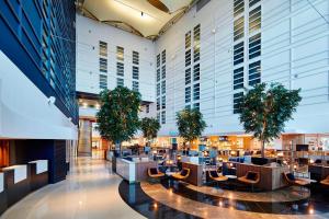 eine Bibliothek mit Sofas und Topfpflanzen in einem Gebäude in der Unterkunft London Heathrow Marriott Hotel in Hillingdon