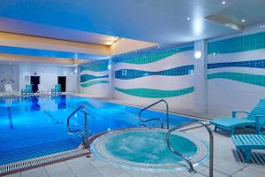 a pool in a hotel with a large swimming pool at London Heathrow Marriott Hotel in Hillingdon