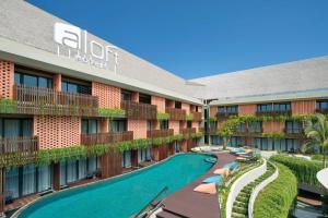 une image de l'avant d'un hôtel avec une piscine dans l'établissement Aloft Bali Kuta at Beachwalk, à Kuta