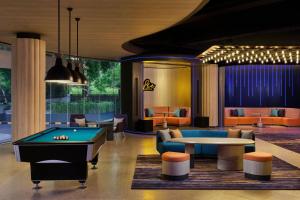 a billiard room with a pool table and couches at Aloft Bali Kuta at Beachwalk in Kuta