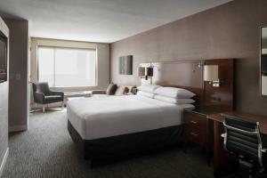 Habitación de hotel con cama blanca grande y escritorio. en Provo Marriott Hotel & Conference Center, en Provo