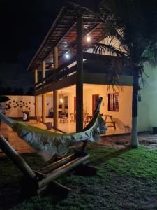 a hammock in front of a house at night at Casa Ferreira Cumbuco in Caucaia