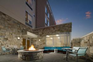 une terrasse avec un foyer extérieur en face d'un bâtiment dans l'établissement SpringHill Suites Bridgeport Clarksburg, à Bridgeport