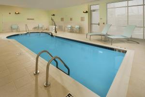 uma grande piscina com cadeiras e mesas em SpringHill Suites Bridgeport Clarksburg em Bridgeport