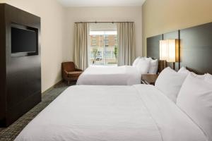 a hotel room with two beds and a television at Residence Inn by Marriott Detroit Farmington Hills in Farmington Hills +20 photos