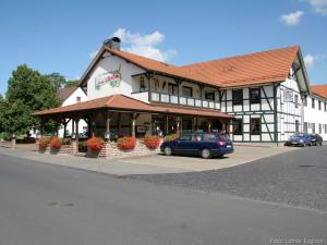 ein blaues Auto, das vor einem Gebäude parkt in der Unterkunft Gasthaus Zur Linde in Kleinvach