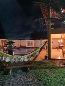 a hammock in front of a pool at night at Casa Ferreira Cumbuco in Caucaia