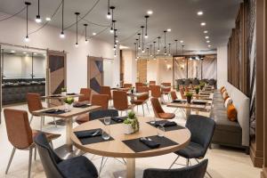 une salle à manger avec des tables et des chaises dans l'établissement Marriott Greensboro Downtown, à Greensboro