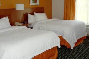 2 letti in camera d'albergo con lenzuola bianche di Fairfield Inn & Suites by Marriott Fairmont a Fairmont
