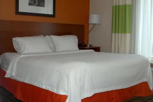 a bed in a hotel room with a white bedspread at Fairfield Inn & Suites by Marriott Fairmont in Fairmont