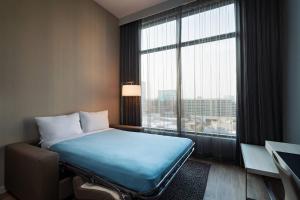a hotel room with a bed and a large window at AC Hotel by Marriott Fort Worth Downtown in Fort Worth