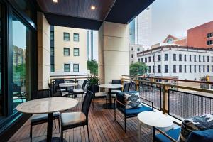 a balcony with tables and chairs and a view of a city at AC Hotel by Marriott Fort Worth Downtown in Fort Worth