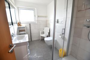 ein Bad mit einem WC, einem Waschbecken und einer Dusche in der Unterkunft Haus Bünzow 1 in Borkum