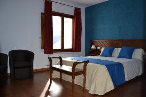 1 dormitorio con 1 cama, 1 silla y 1 ventana en Hotel Rural Ibipozo, en El Almicerán