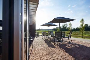 eine Terrasse mit Tischen, Stühlen und Sonnenschirmen in der Unterkunft Fairfield Inn & Suites by Marriott Kansas City Belton in Belton