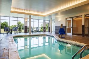 a swimming pool with a blue chair in a house at Fairfield Inn & Suites by Marriott Kansas City Belton in Belton