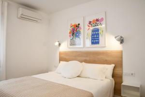 sypialnia z łóżkiem i 2 zdjęciami na ścianie w obiekcie Casa Maui w mieście Banyoles