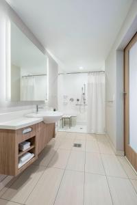 a white bathroom with a sink and a shower at SpringHill Suites Madison in Madison