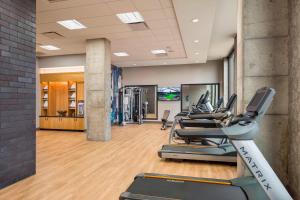 a gym with treadmills and a row of exercise bikes at SpringHill Suites Madison in Madison