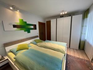 ein Schlafzimmer mit einem großen Bett mit gelben und blauen Kissen in der Unterkunft Ferienwohnung Hilger in Treis-Karden