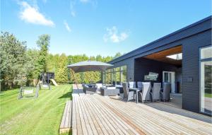 una terraza con sillas y una sombrilla en una casa en Amazing Home In Vggerlse With Wifi, en Bøtø By